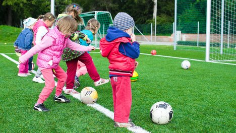 Kleine Kinder spielen Fußball